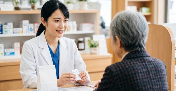 調剤薬局で薬剤師が服薬指導する様子